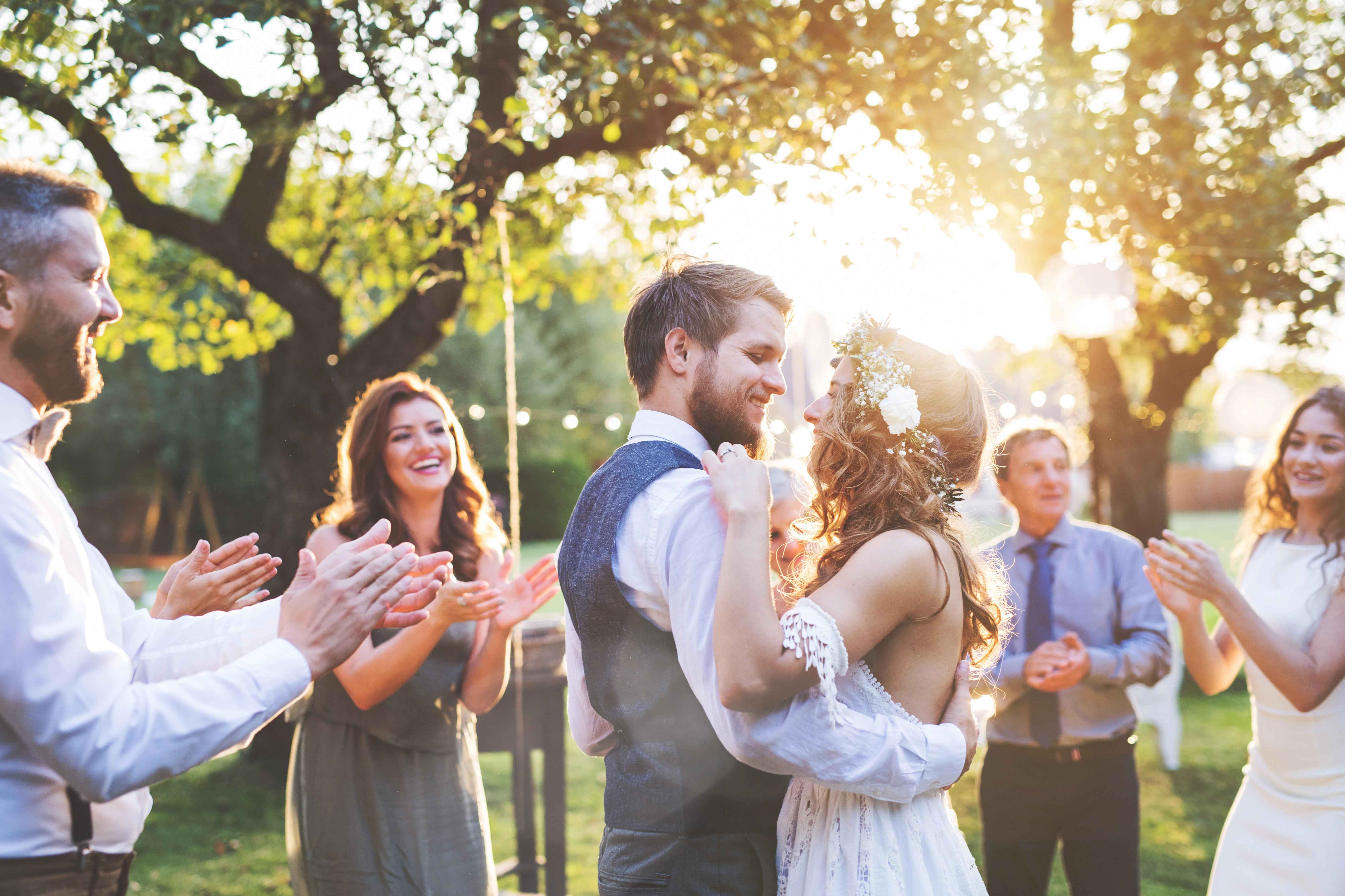 Newlyweds dancing outdoors with their wedding guests
